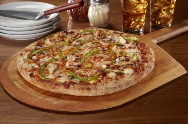 A Barro's chicken supreme pizza on a wooden board
